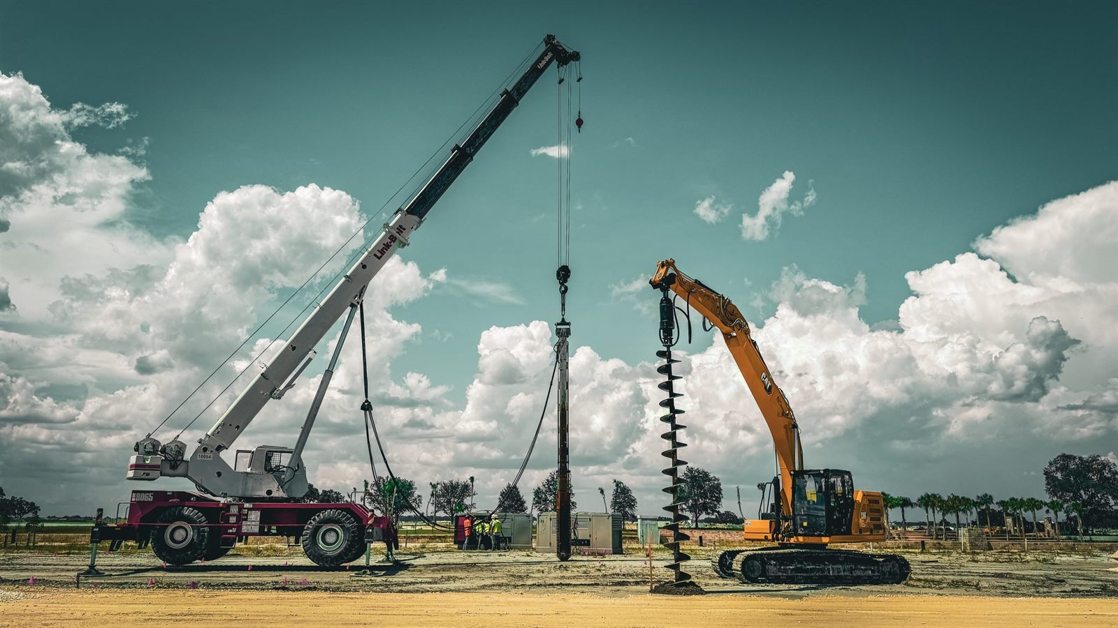 Drilling rig and excavator working an active site
